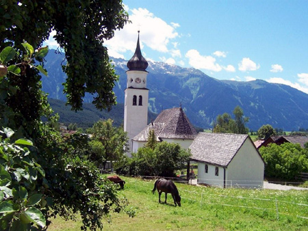 Kirche Wildermieming mit Blick auf die Stubaier Alpen.